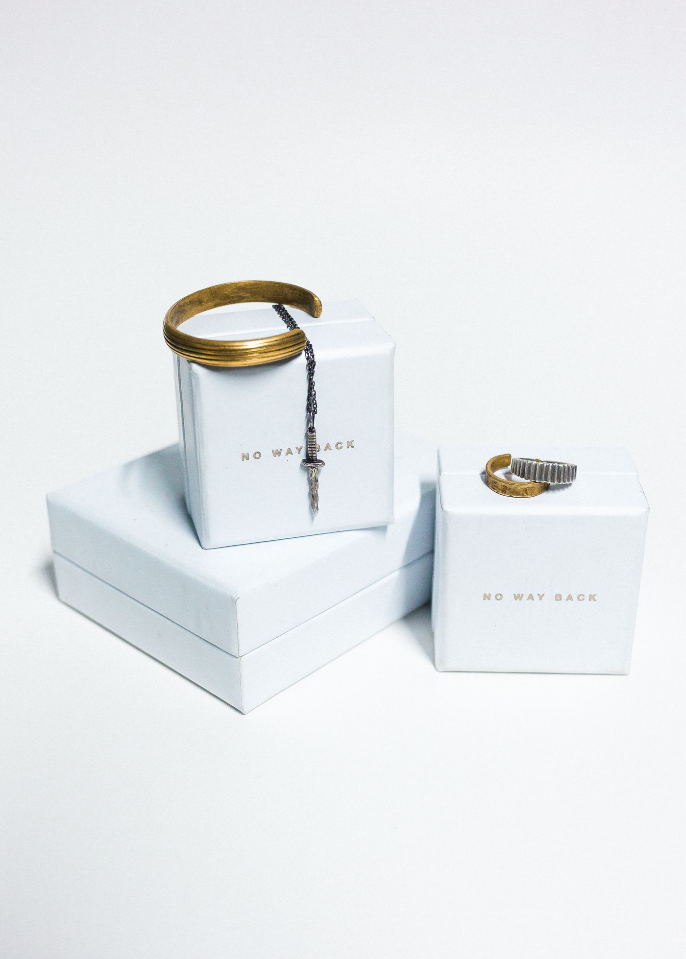 A gold ring resting on a white jewellery gift box